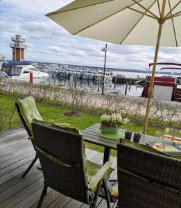 une table et des chaises avec un parasol sur une terrasse dans l'établissement 2 Zimmerapartment 2 Terrassen P7a1, à Plau am See