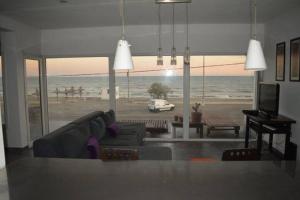 ein Wohnzimmer mit Couch und Blick aufs Meer in der Unterkunft CASA AL LADO DEL MAR in Balneario El Cóndor