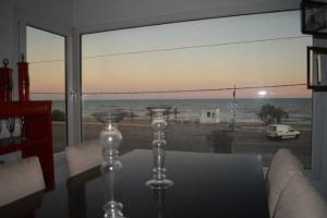 Zimmer mit einem Glastisch und Meerblick in der Unterkunft CASA AL LADO DEL MAR in Balneario El Cóndor