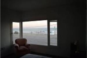 ein Zimmer mit einem Fenster mit einem Stuhl und einer Aussicht in der Unterkunft CASA AL LADO DEL MAR in Balneario El Cóndor + 1 Foto