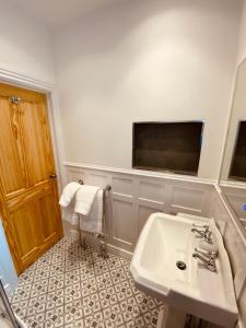 a bathroom with a sink and a tv on the wall at Self Contained Guest suite 2 - Weymouth in Weymouth
