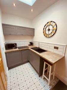 una cocina con fregadero y un reloj en la pared en Self Contained Guest suite 2 - Weymouth en Weymouth