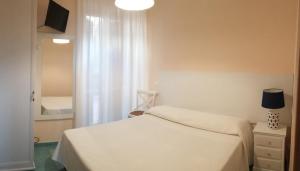 a bedroom with a white bed and a window at VILLA FLORA ARGENTARIO in Porto Santo Stefano