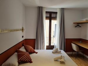 a bedroom with a bed with two towels on it at Cálamo Guesthouse in Madrid +164 photos