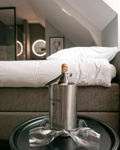 a bottle of champagne in a bucket on a table in front of a bed at "Het Wapen Van Willemstad" in Willemstad