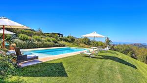 a swimming pool with two chairs and an umbrella at Casale Le Conce 62 Emma Villas in Castel del Piano