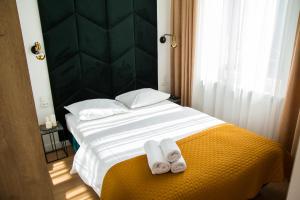 een slaapkamer met een bed met twee handdoeken erop bij Emerald Room in Toruń