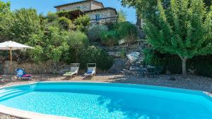 a swimming pool with chairs and a house in the background at CASALE SALLY 6, Emma Villas in Baschi