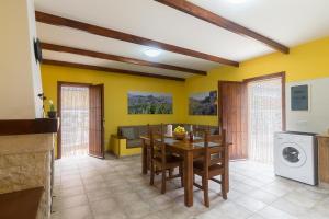 comedor con paredes amarillas, mesa y sillas en Casa Rural Ayacata en San Bartolomé