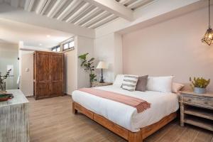 1 dormitorio con cama grande y mesa de madera en Casa Pandurata Luxury Apartments in Centro, San Miguel de Allende en San Miguel de Allende