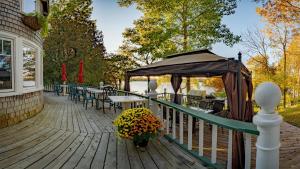a deck with tables and chairs and an umbrella at Windswept on the Trent in Campbellford