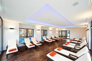 a waiting room with white chairs and orange pillows at Kreuz-Post Hotel-Restaurant-SPA in Vogtsburg