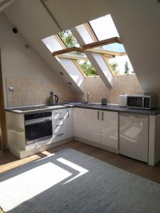 a kitchen with white cabinets and a roof with skylights at #MazuryLove in Giżycko