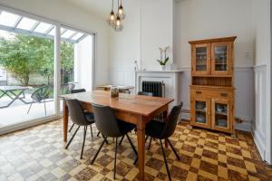 uma sala de jantar com uma mesa de madeira e cadeiras em Trendy, authentieke woning met groot terras en tuin em Bruges