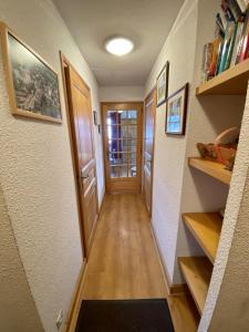 - un couloir d'une maison avec une porte et des étagères dans l'établissement La Troïka, à Notre-Dame-de-Bellecombe
