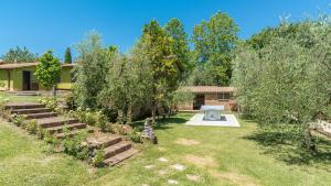 einen Garten mit einer Bank und Bäumen sowie ein Haus in der Unterkunft Country House Montepietraia E San Martino 18, Emma Villas in Sutri