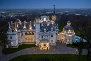 an aerial view of a large house with lights at BOTANIQ Castle of Tura - Small Luxury Hotels of the World in Tura