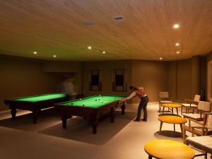 a woman playing pool in a billiard room at Valle Corralco Hotel & Spa in Malalcahuello