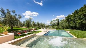 - une piscine dans une cour avec des chaises et un parasol dans l'établissement DIMORA SAN GERMANO 14, Emma Villas, à San Miniato