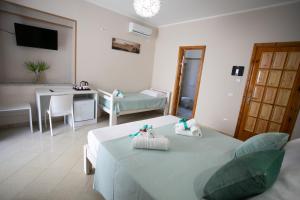 una habitación de hotel con 2 camas y una mesa y una habitación en B&B Leonida, en Tropea