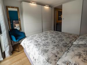 a bedroom with a bed and a blue chair at Swebenhus boven - 4 Sterne-Appartement in Plau am See