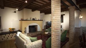 ein Wohnzimmer mit einem Sofa und einem Kamin in der Unterkunft IL BORGO 16, Emma Villas in Assisi