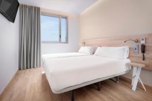a bedroom with a white bed and white walls at B&B Hotel Murcia in Murcia