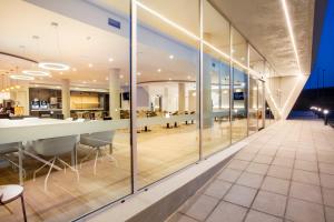 una oficina con paredes de cristal y una mesa y sillas largas en B&B HOTEL Murcia, en Murcia