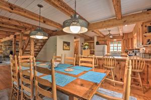 a dining room and kitchen with a wooden table and chairs at Riversong Cabin with Fire Pit on North River in Slanesville
