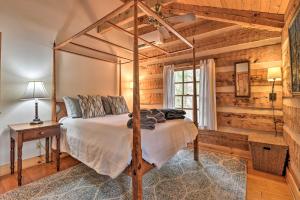 a bedroom with a bed in a room with wooden walls at Riversong Cabin with Fire Pit on North River in Slanesville