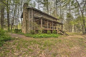 a log cabin in the middle of a forest at Riversong Cabin with Fire Pit on North River in Slanesville
