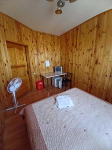 a bedroom with a bed and a desk with a computer at Бирюза in Karolino-Buhaz