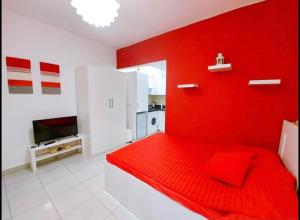 um quarto vermelho com uma cama vermelha e uma cozinha em Delta Sharm Holiday em Sharm el Sheikh