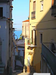 un callejón con edificios y el océano en el fondo en Nonna Libera monolocale, en Rodi Garganico