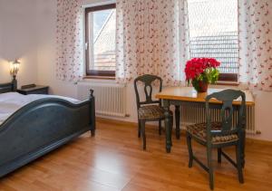 a bedroom with a table and two chairs and a bed at Hotel Garni Botenwirt in Spital am Pyhrn