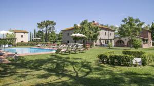 un cortile con sedie, una piscina e una casa di Le Caselle 26, Emma Villas a Cortona