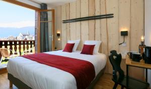a bedroom with a large bed and a balcony at Hôtel Restaurant La Buffe in Autrans