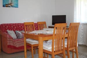 a dining room with a table and chairs and a couch at Apartment Zmisa in Stara Novalja