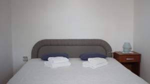 a bed with two pillows and two towels on it at Apartment Zmisa in Stara Novalja
