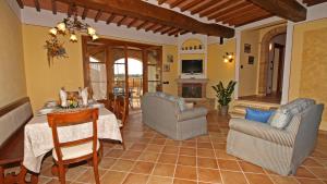 una cucina e un soggiorno con tavolo e sedie di Le Terre Di Nunzio 12, Emma Villas a Montepulciano