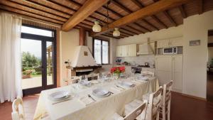 a dining room with a long table in a kitchen at L'Ovile 8, Emma Villas in Sovicille
