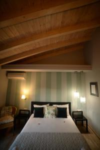 a bedroom with a large bed with a wooden ceiling at Grimani Pension in Nafplio