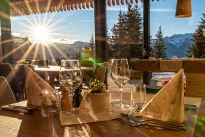 a table with wine glasses and a view of the mountains at Oberhauser Hütte Rodenecker - Lüsner Alm in Luson