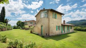 an old house with green shutters on a yard at PODERE GRAGNANO 12, Emma Villas in Cetona