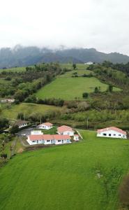 an aerial view of a large green field with houses at El Pueblín de Ribadesella in Ribadesella