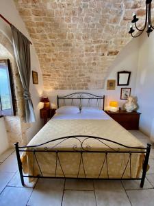 - une chambre avec un lit et un mur en briques dans l'établissement La Guendalina Masseria e Casa Particular, à Monopoli