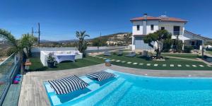 a swimming pool with two lounge chairs and a house at Kasparis View Residence in Pano Lefkara