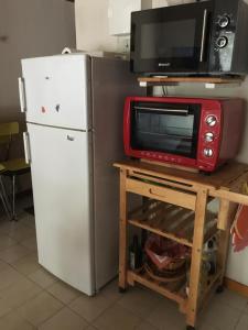 a kitchen with a microwave and a refrigerator at Les pins ensoleilles in Saint-Georges-de-Didonne