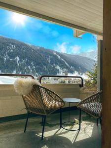two chairs and a table on a balcony with a view at Wunderstay Alpine 403 Centric Studio Balcony/View in Davos
