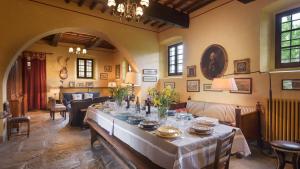 a dining room with a long table with dishes on it at Poggerello 18, Emma Villas in Laterina